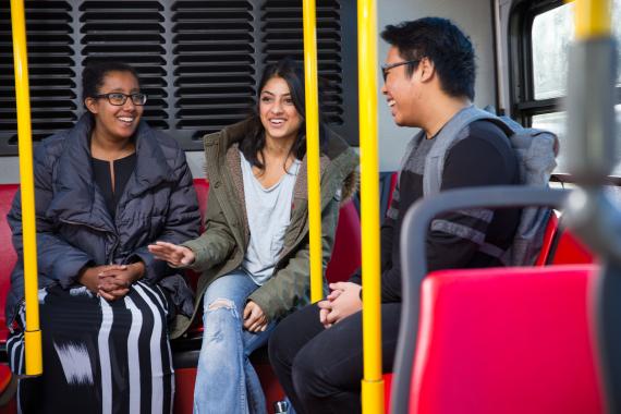 three students sitting on shuttle bus